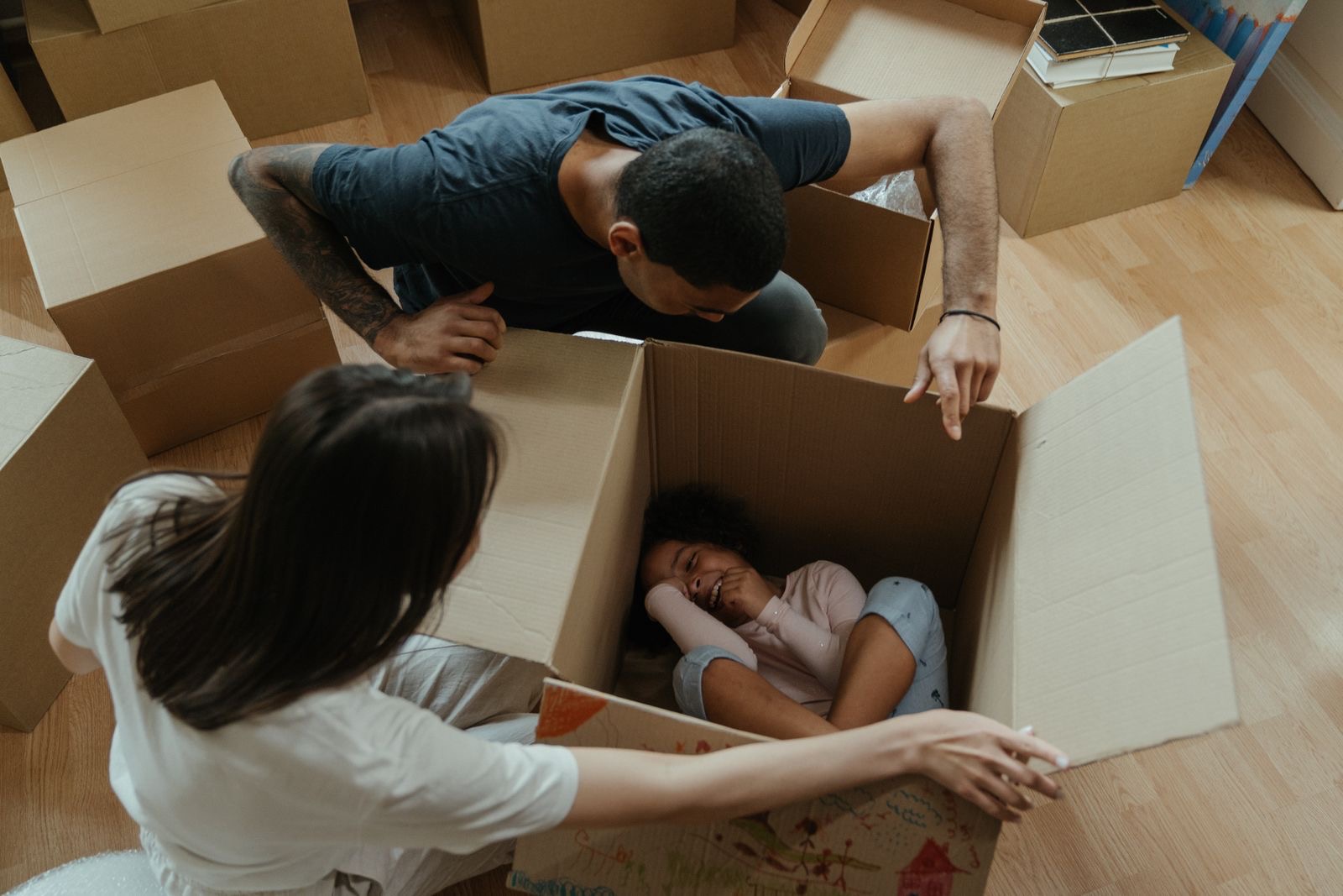 Two adults and two children unpacking moving boxes in a new living room