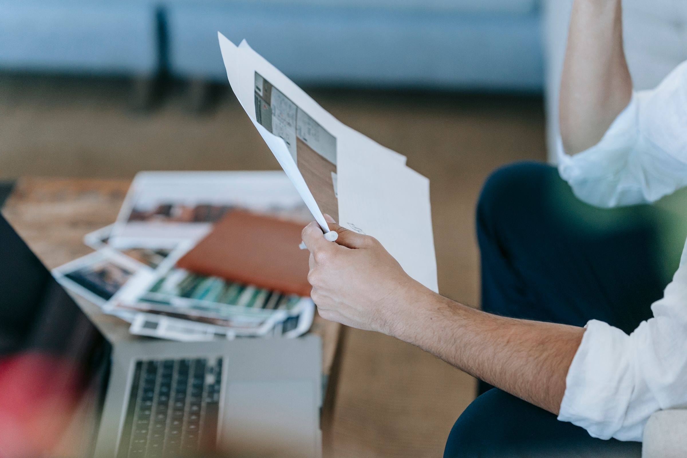 A founder at a desk going through a folder of company papers next to an open laptop
