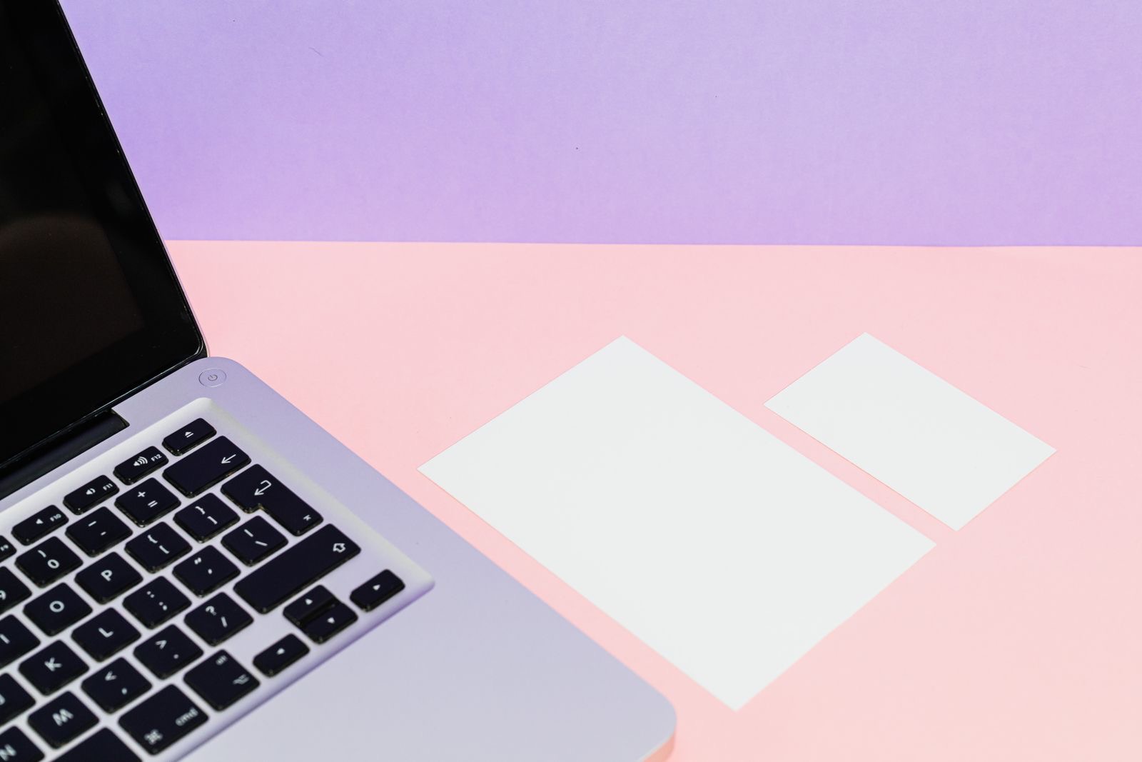 Blank business cards beside a laptop
